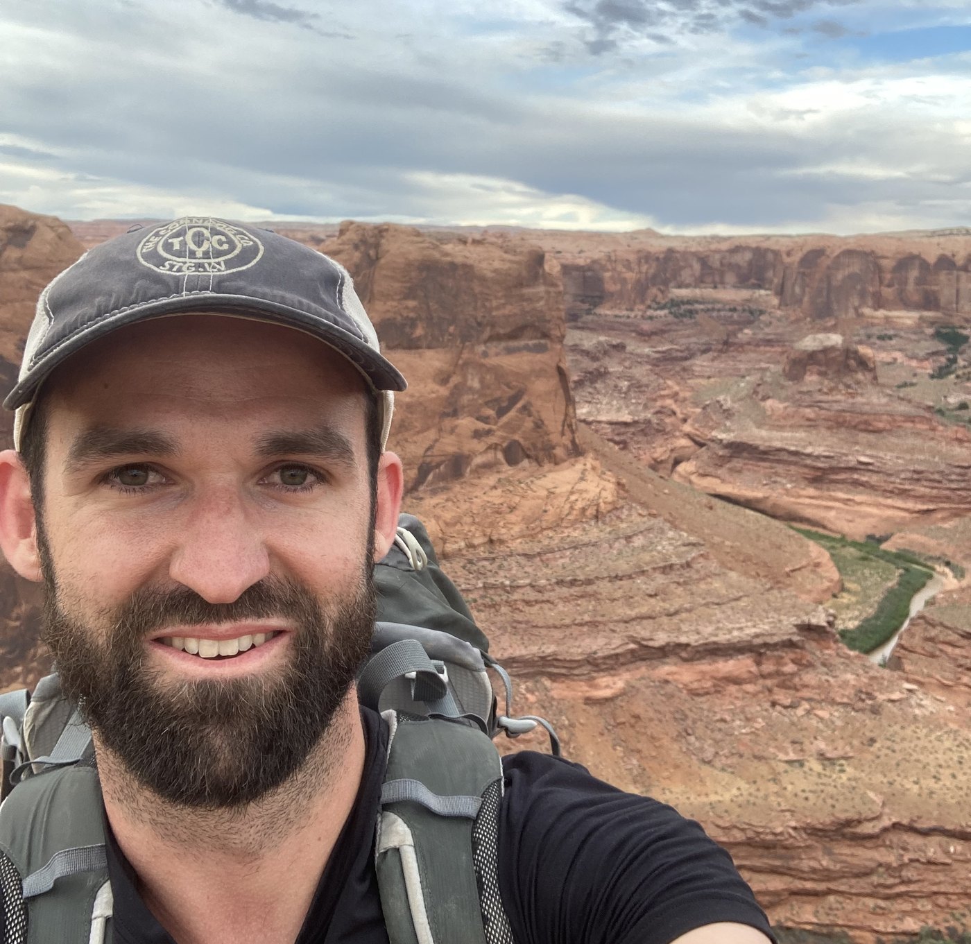 Tyler Patten backpacking above a red rock canyon in southern Utah